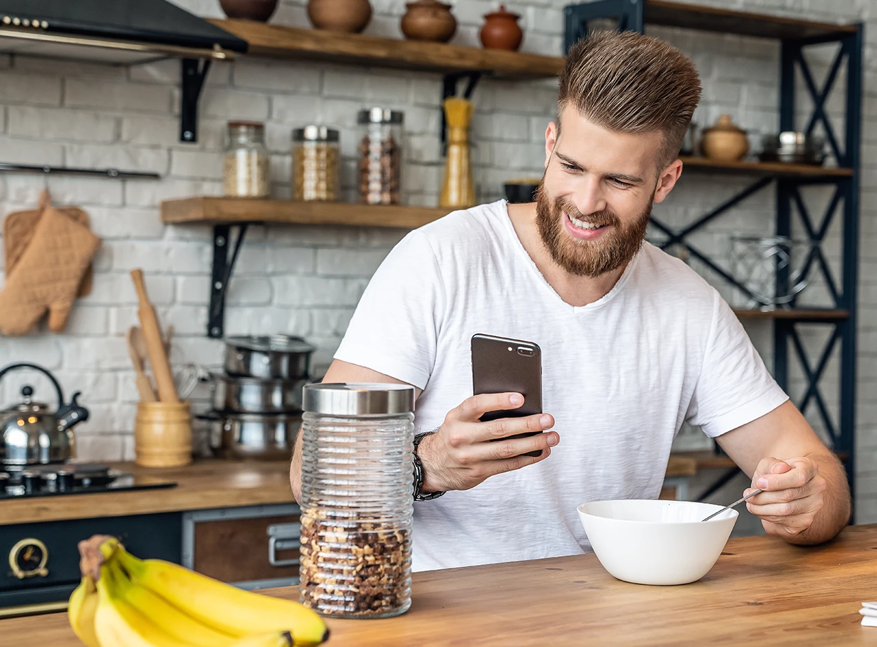 Man eating breakfast looking at his phone